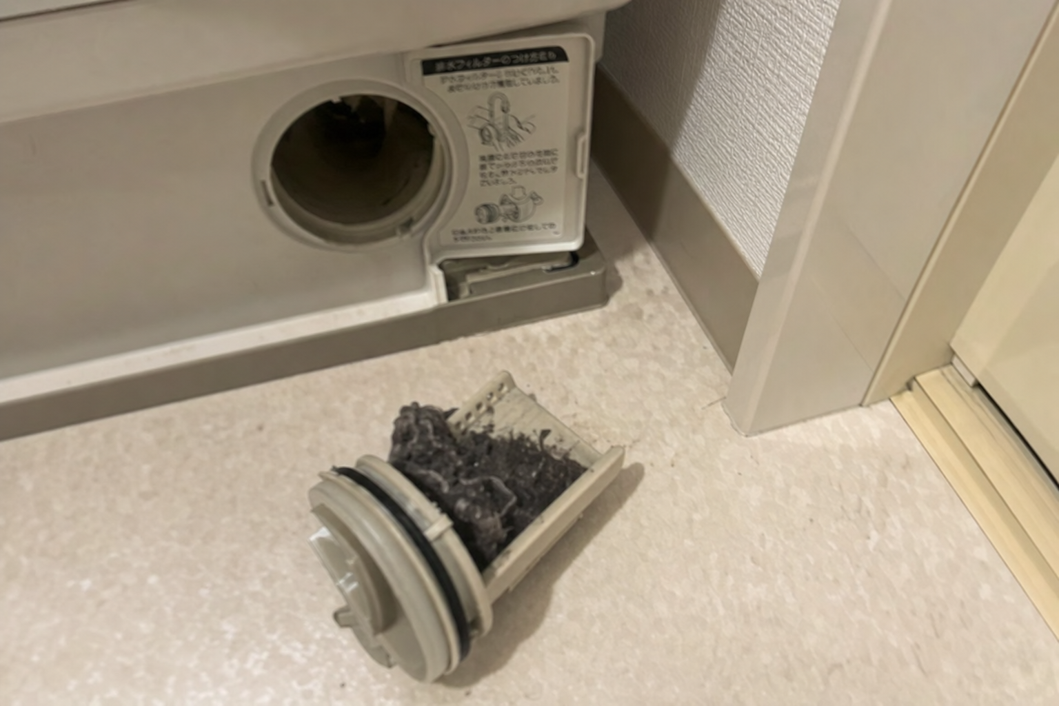 洗濯機の排水フィルターが詰まっている様子